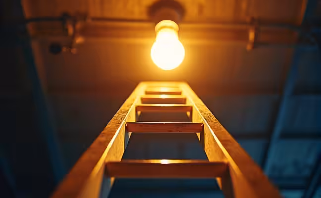 A close-up image of a sturdy ladder reaching up towards a ceiling light bulb, symbolizing tasks that require height. The ladder should appear robust and safe, emphasizing the importance of a good safety rating. The light bulb should be slightly out of reach, underlining the necessity of the ladder